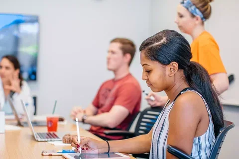 Woman sitting at desk taking notes.